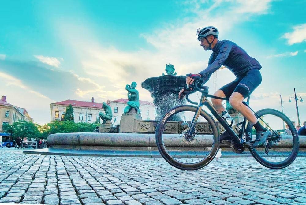 A man riding in blue long sleeve shirt riding a bicycle during daytime