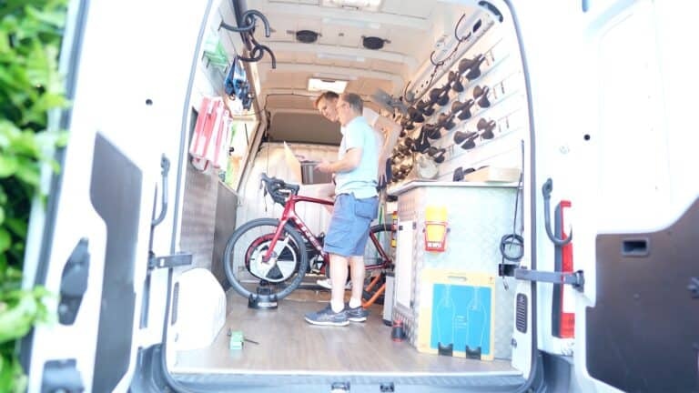 side view of cyclist and bike fitter checking saddle pressure map test results