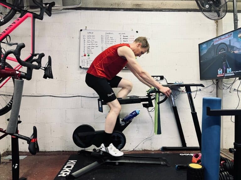 A man on a stationary bike in a garage.