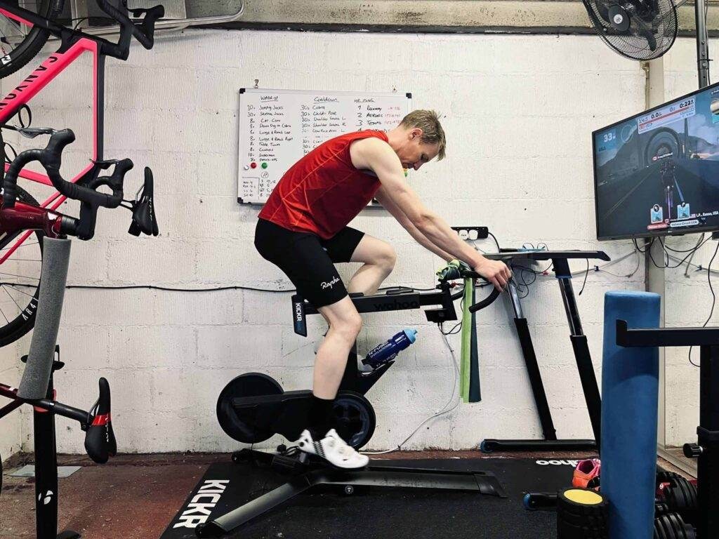 A man on a stationary bike in a garage.