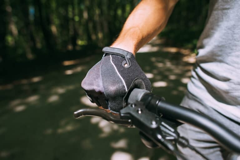 Hands of a  in a sports  gloves holding on to the steering wheel