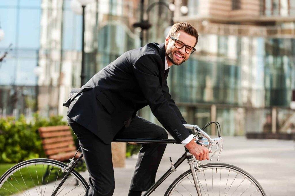 A man in a suit is riding a bicycle.
