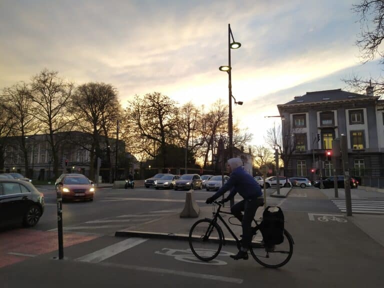 Man in blue shirt riding bicycle on road