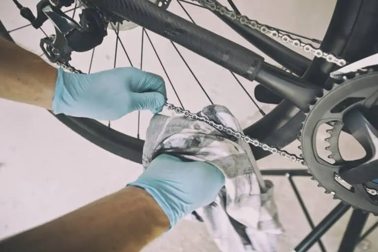The mechanic is fixing the road bicycle in his workshop