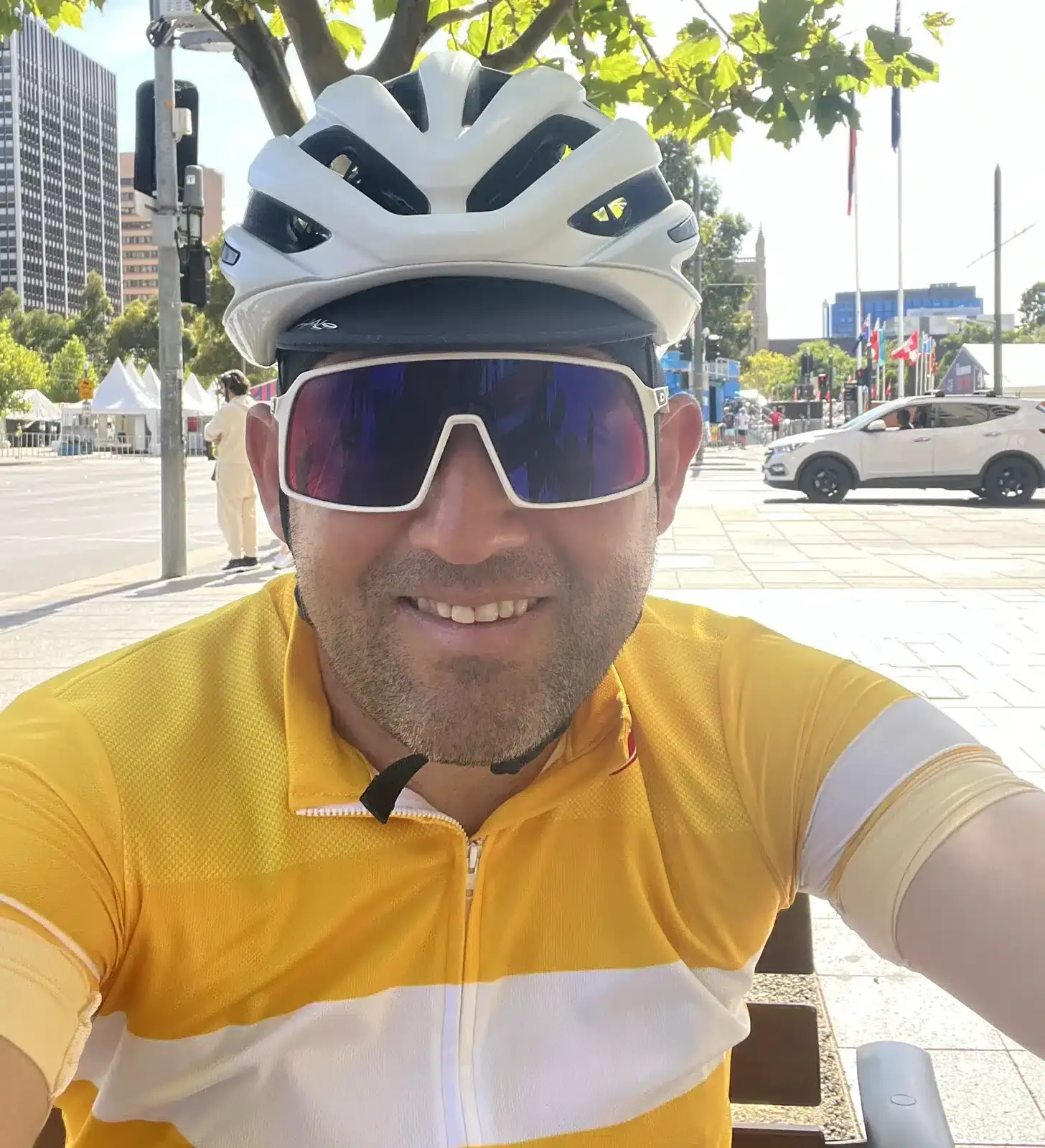 Rhys Smith Writer Rhys wearing a helmet and sunglasses takes a selfie in an urban setting.