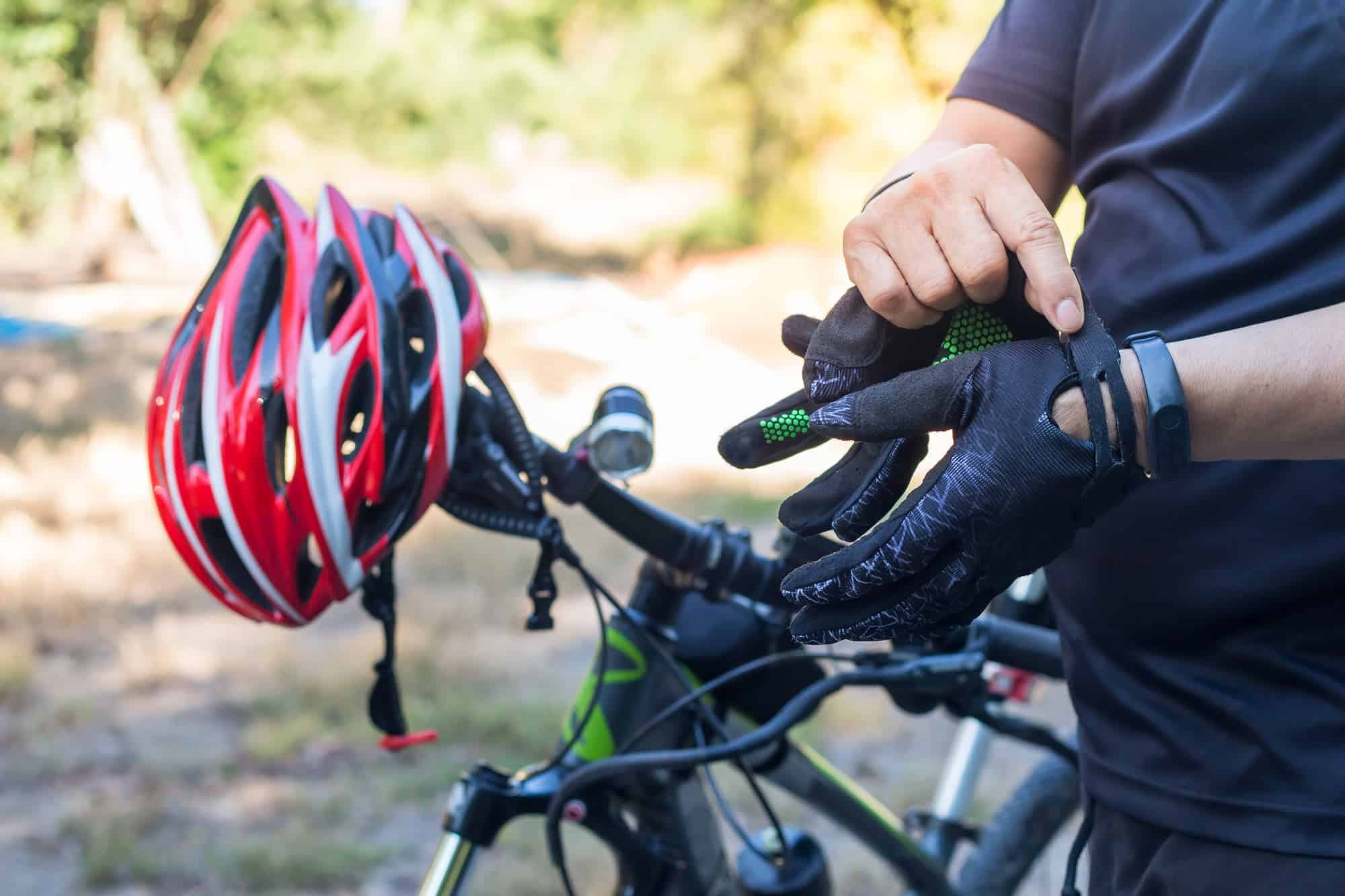 Man with helmet glove for safety riding a bicycle at countryside