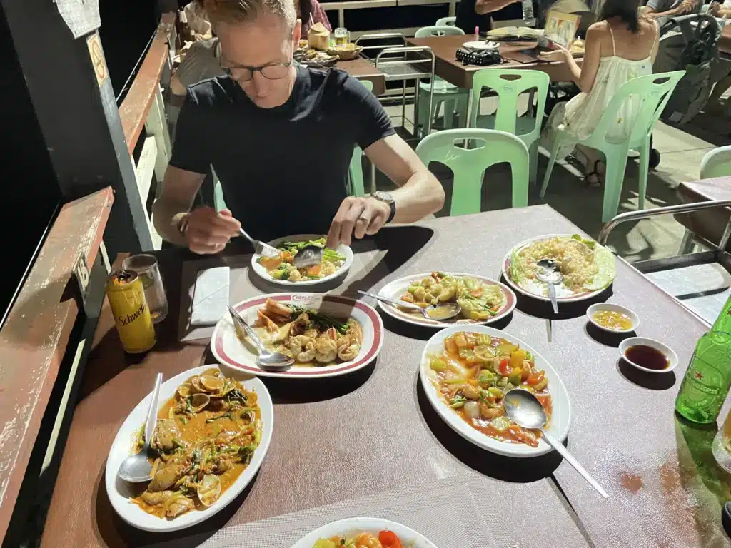 They're chilling at a busy outdoor spot, surrounded by plates of food